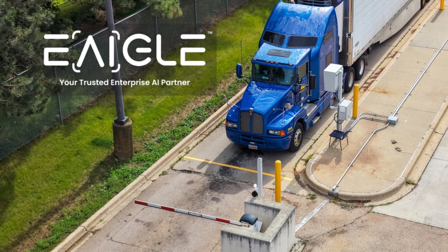 Aerial view of a blue semi-truck entering a secured facility checkpoint, illustrating EAIGLE's enterprise AI technology for automated gate access, security screening, and commercial vehicle operations.