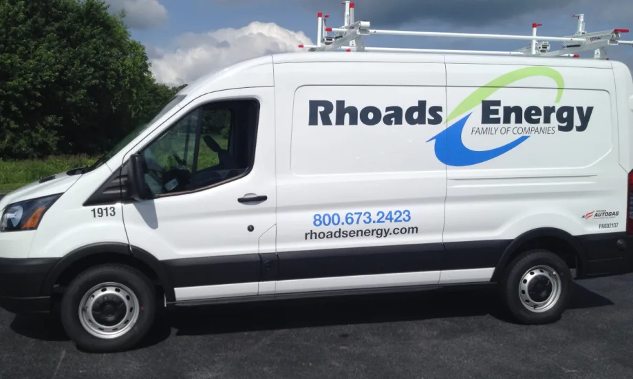 Photo of the side of a Ford Transit service van with company logo for Rhoads Energy.