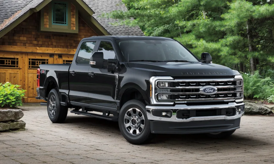 Black Ford Super Duty pickup truck parked in driveway of a home.