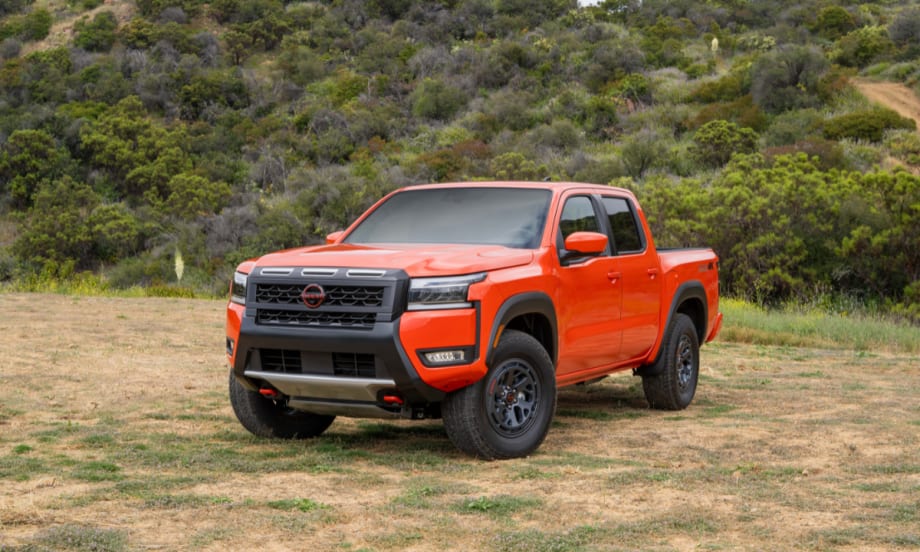 2026 Nissan Frontier PRO-4X in red parked outdoors on grass.