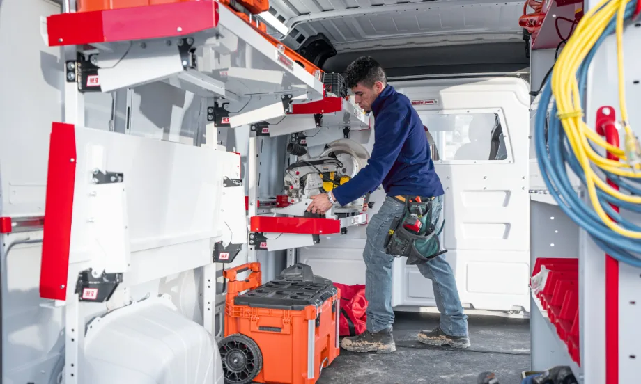 Worker inside a van with upfit shelving.