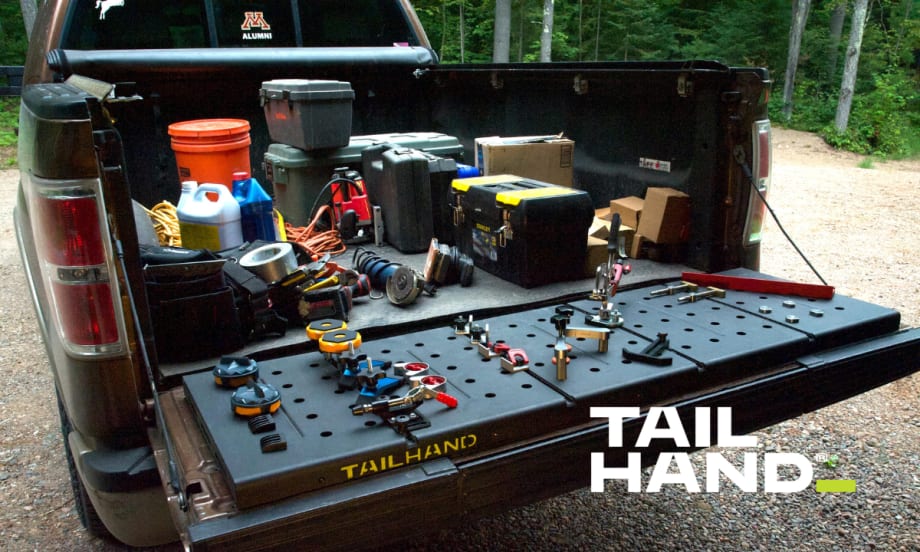 Pickup tailgate lowered and being used to secure tools.
