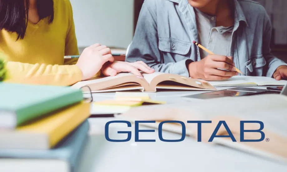 Two students study with books and notes at a desk. Geotab partners with Georgia Tech on $223K traffic data research to improve safety and urban mobility.