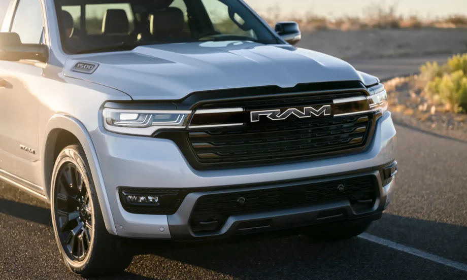 Front view of the Ram 1500 REV electric pickup in silver, showing bold RAM grille and headlights. The range-extended truck replaces Ram’s BEV plans, offering strong towing, payload, and range.