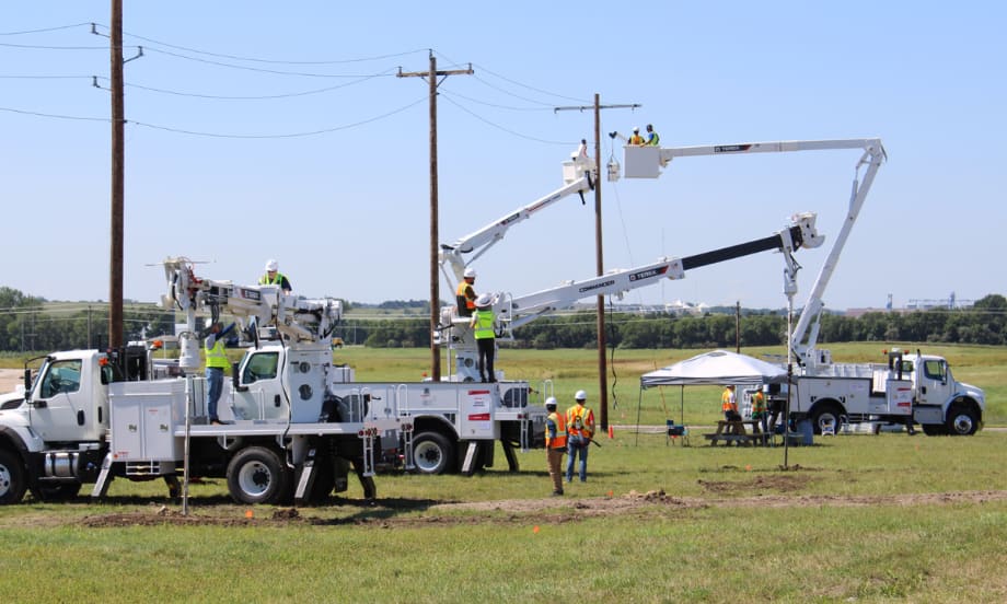 Utility workers operate Terex digger derricks and aerial devices in a field training session, practicing pole setting and aerial lifts during the Terex Utilities Hands-On Training event.