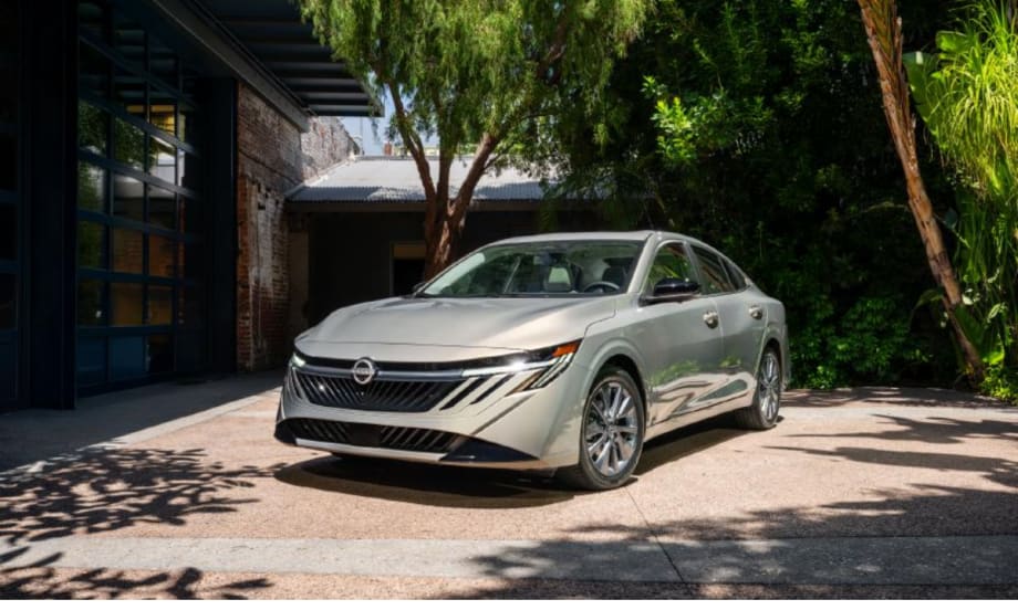 A silver 2026 Nissan Sentra parked in a courtyard, showcasing its redesigned front grille and headlights.