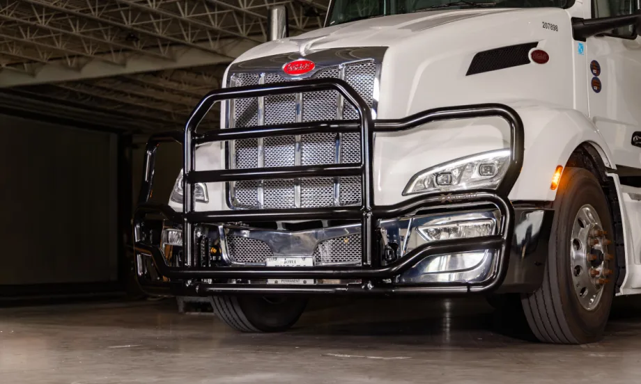 Black grille guard on front of a white tractor trailer, viewed from a front/side angle.