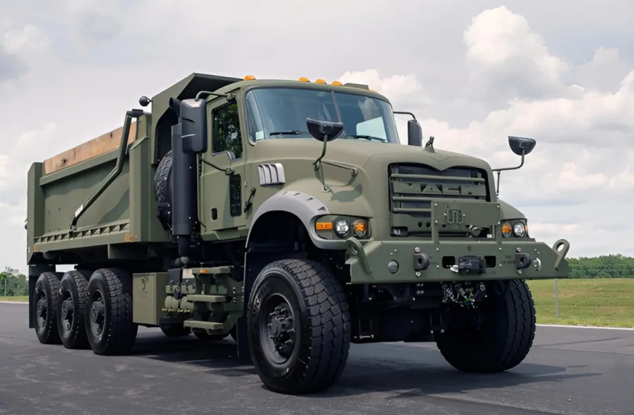 Military dump truck shown from the front quarter low angle.