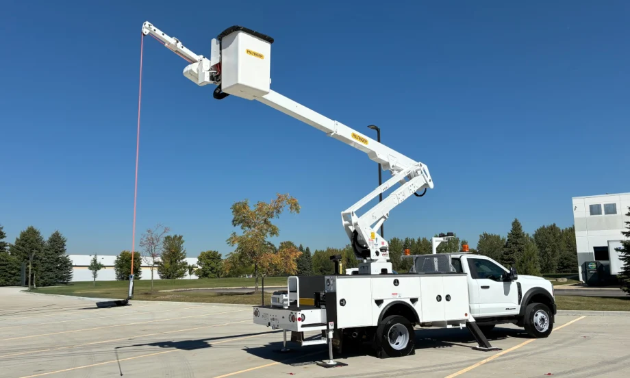 A utility bucket truck extended against a blue sky.