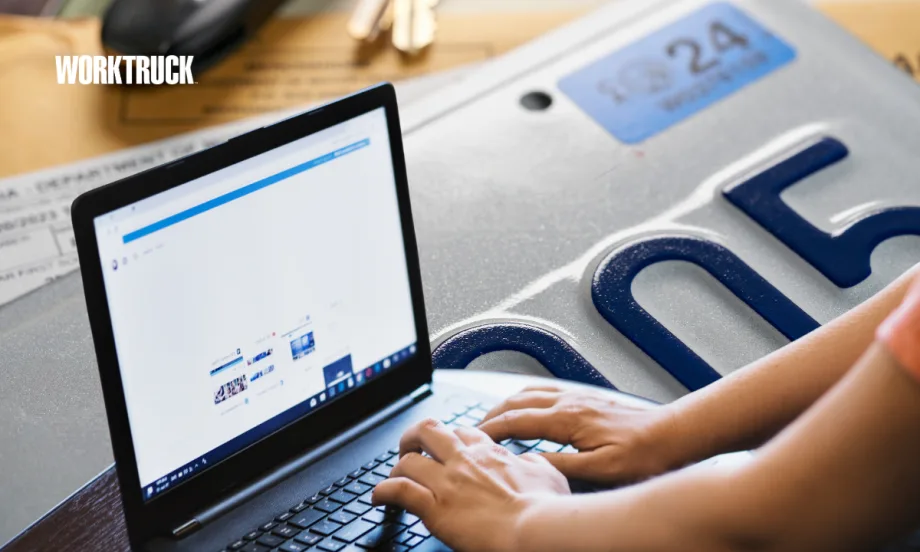 Person using a laptop beside a vehicle license plate, representing how fleets use technology to manage registrations, track renewals, and stay compliant across multiple jurisdictions.