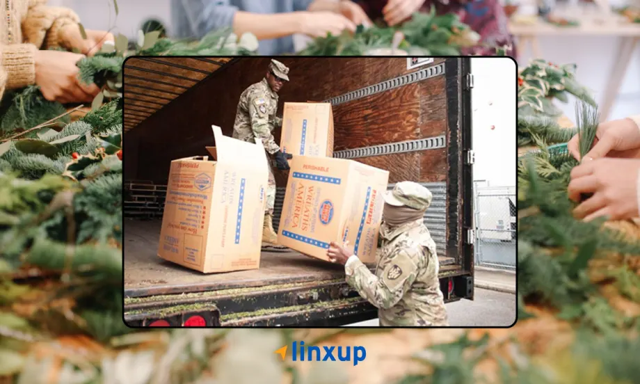 Service members unloading Wreaths Across America boxes from a truck as volunteers prepare wreaths, highlighting Linxup’s support and participation in honoring veterans.