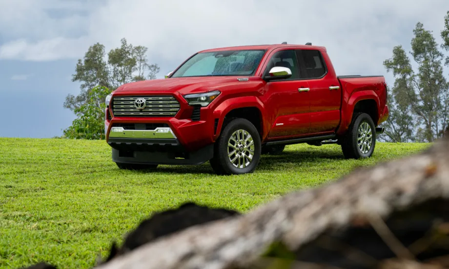 Red four-door Toyota pickup parked in a grassy area.