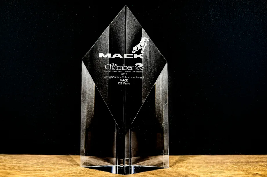 Photo of a glass looking clear award with name Mack Trucks set against a black background.