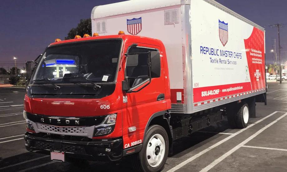 Box truck with a red cab parked in a parking space.