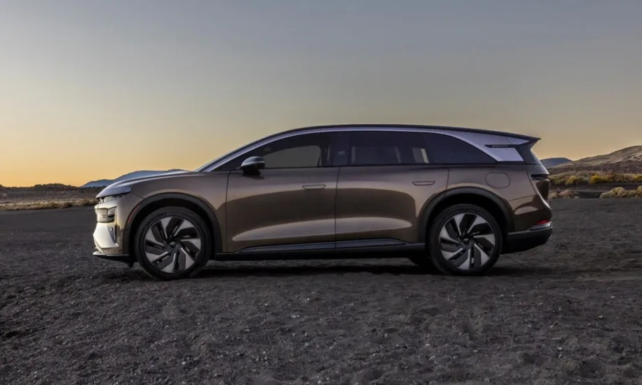 Side profile of the Lucid Gravity Touring electric SUV parked at sunset in a desert landscape.