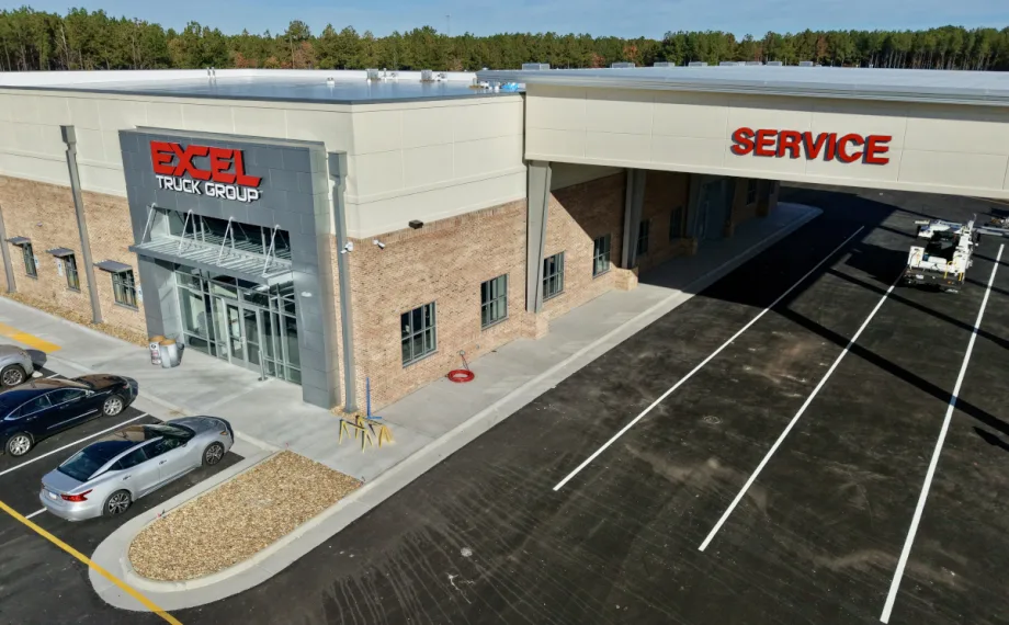 Slightly overhead view of a new truck dealership with one overhang labeled Service.