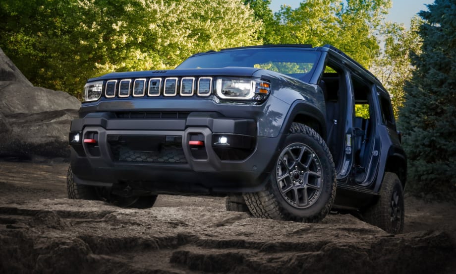 Jeep Recon on rocky terrain with one door removed and LED lights on.