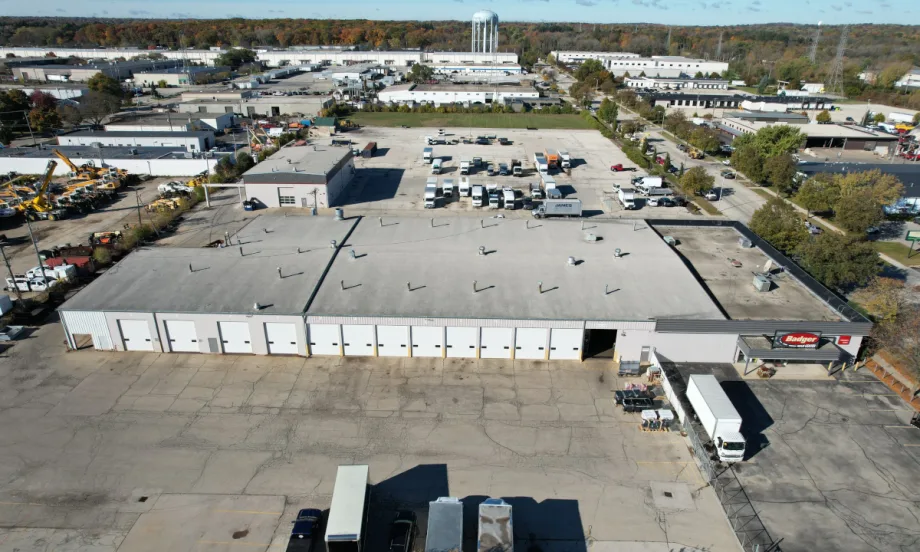 aerial view of an industrial looking large building with large parking areas.