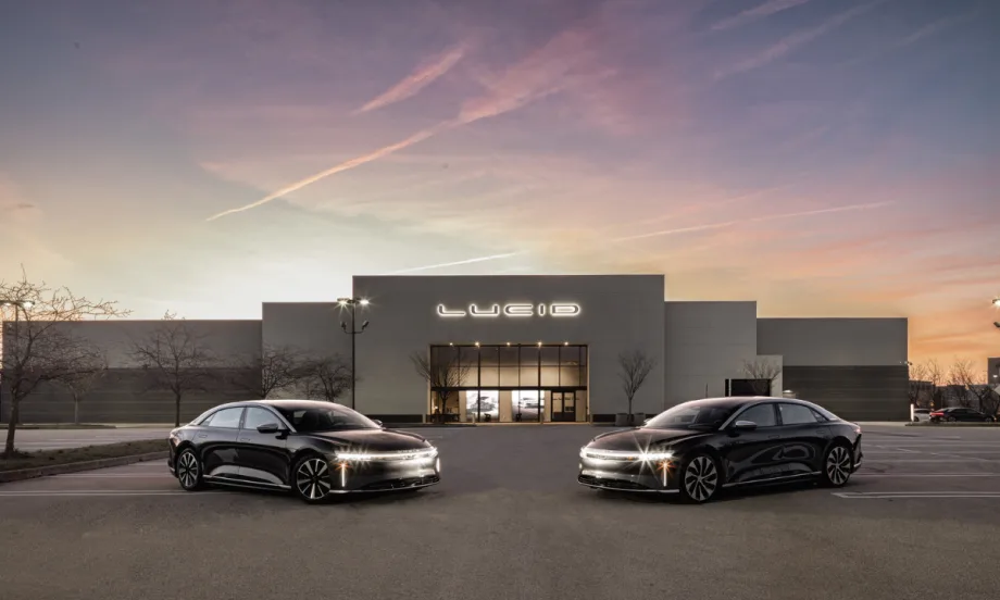 Two Lucid electric sedans parked in front of a Lucid facility at dusk, representing the automaker’s new certified pre-owned vehicle program.