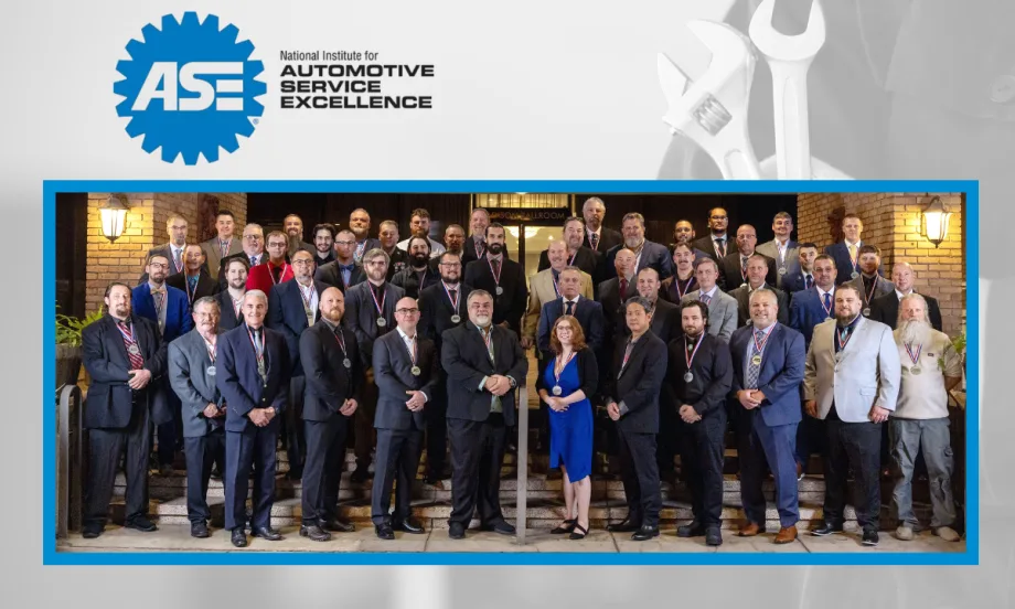 Group of award winners standing in three or four rows and all dressed in business attire. ASE logo top left.