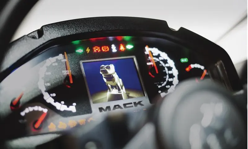 Closeup photo of a truck instrument cluster with a digital dash including an image of the Mack bulldog.