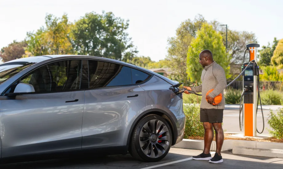 Photo of a man charging an EV car.