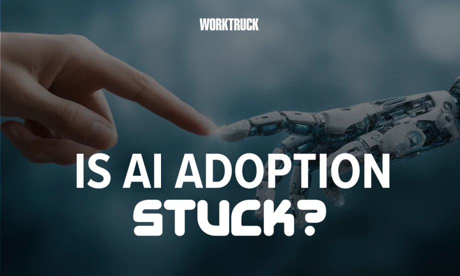 Work Truck graphic reading “Is AI Adoption Stuck?” with a human and robotic hand touching, illustrating fleet AI adoption trends from Fleetio’s 2026 report.