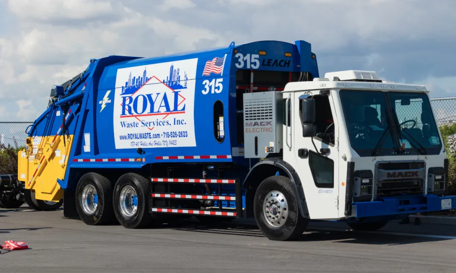 Front quarter view of a blue electric refuse truck.