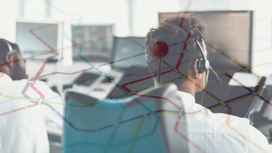 Dispatchers monitoring screens with route map overlay representing fleet telematics combined with human reporting for disaster response coordination