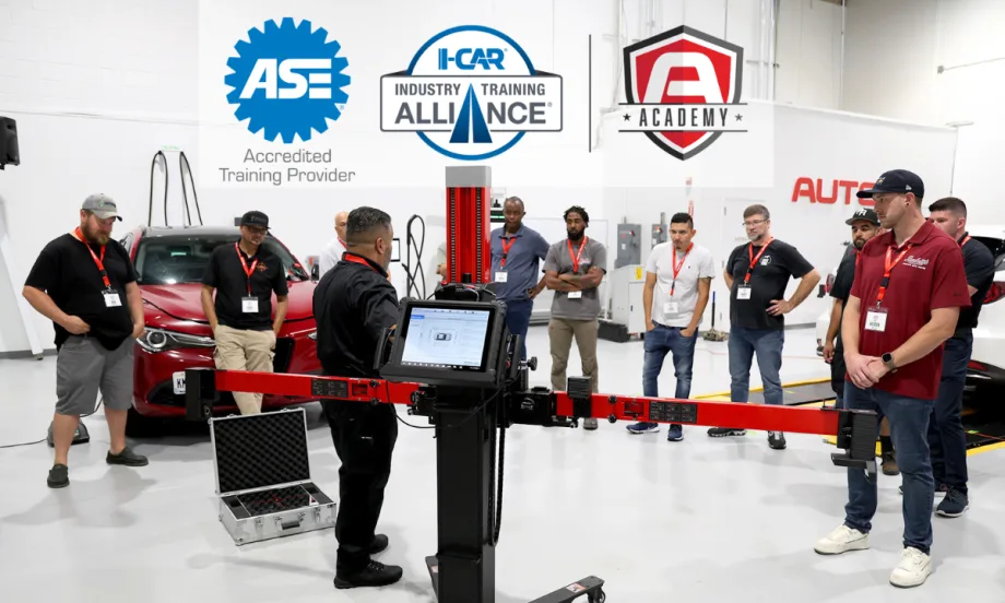 Group of automotive technicians in a circle learning during a training class, with three logos across the top of the image.