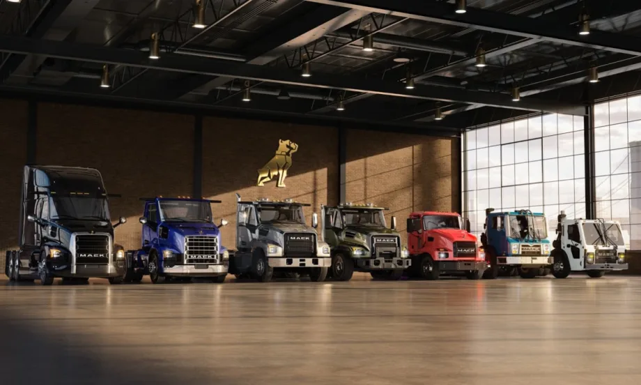 Lineup of Mack Trucks parked inside a warehouse.