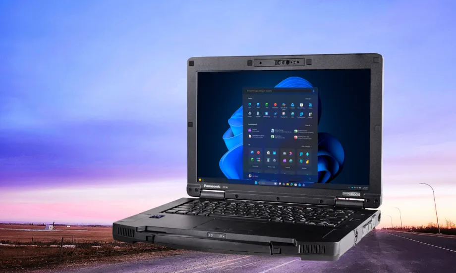 Photo of an open laptop computer against background of a sky at dusk.