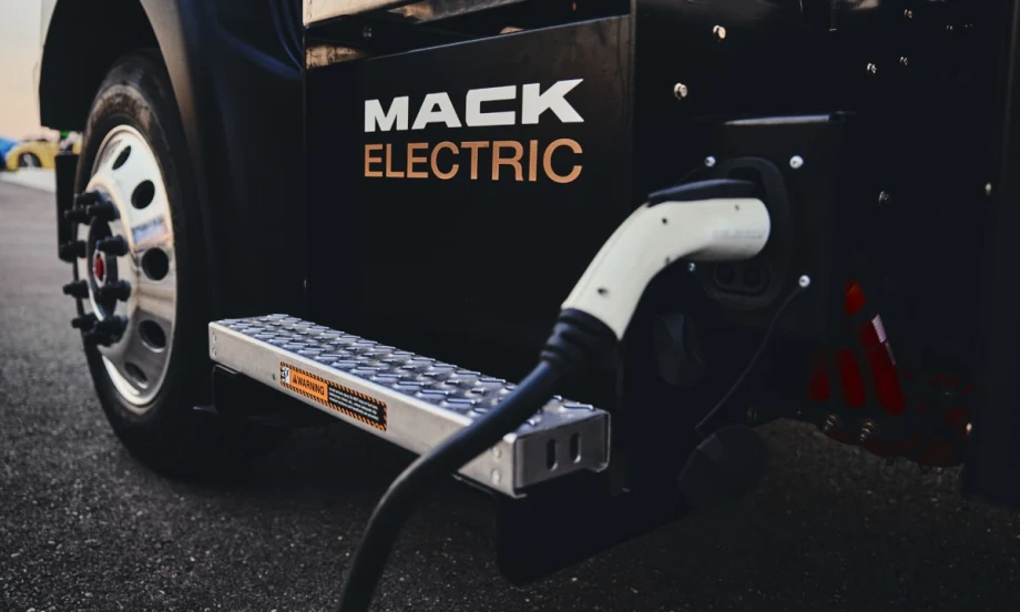 Closeup view of an EV charger plugged into a black truck with the logo for Mack Electric on the side.