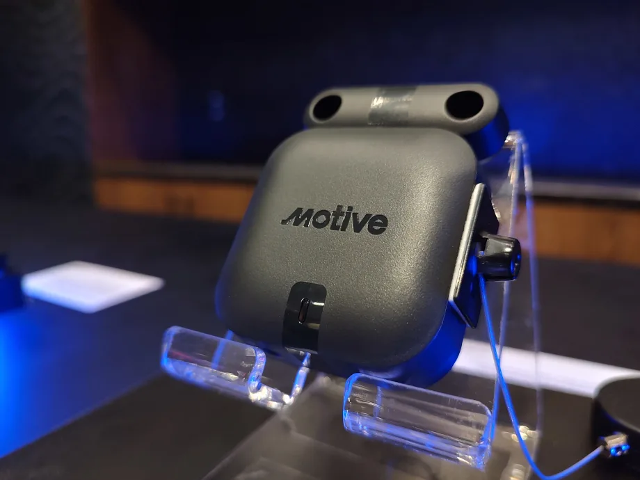 Close-up of a Motive-branded sensor device displayed on a clear stand under blue lighting, likely used for fleet monitoring or environmental and door tracking applications.