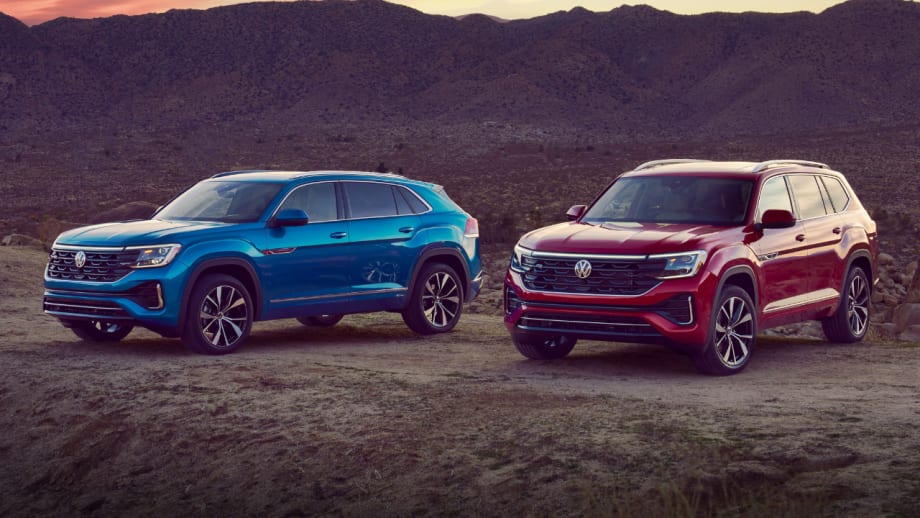 Two Volkswagen SUVs, a blue Tiguan and a red Atlas, are parked on a desert overlook with mountains in the background. The 2026 Atlas and Tiguan were recently named Consumer Reports Recommended vehicles based on safety, reliability, owner satisfaction, and road-test performance.