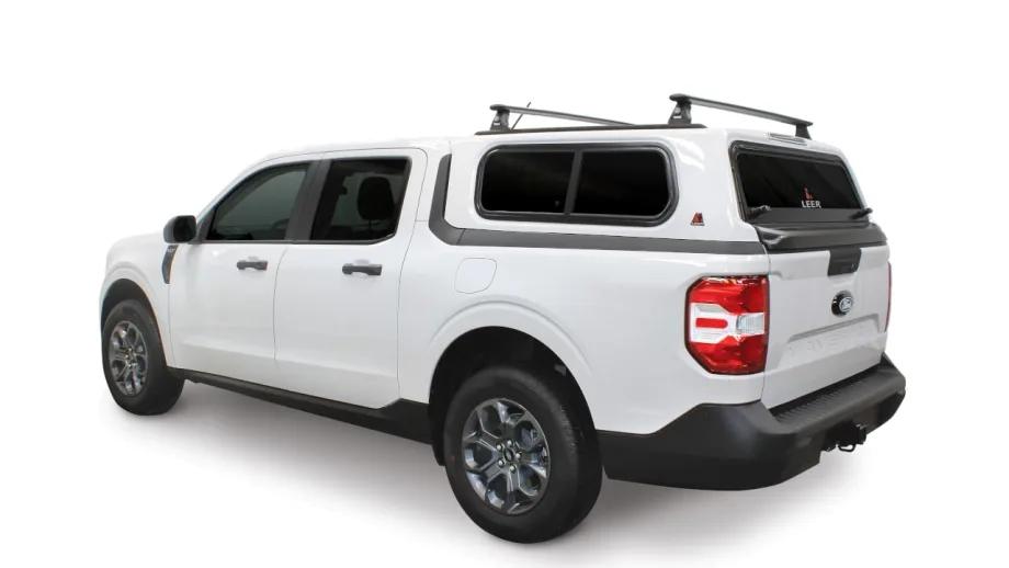 White Ford Maverick pickup equipped with a LEER truck cap and roof rack, shown from the rear three-quarter view, highlighting an integrated cargo solution for fleet, commercial, and utility applications.