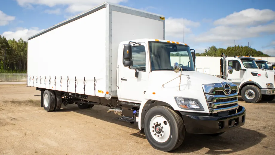 White medium-duty truck equipped with a Marion curtainside body featuring a retractable side curtain and multiple lower fasteners.