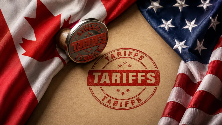 Canadian and U.S. flags frame a red “TARIFFS” stamp on a document, illustrating escalating trade tensions between the two countries.