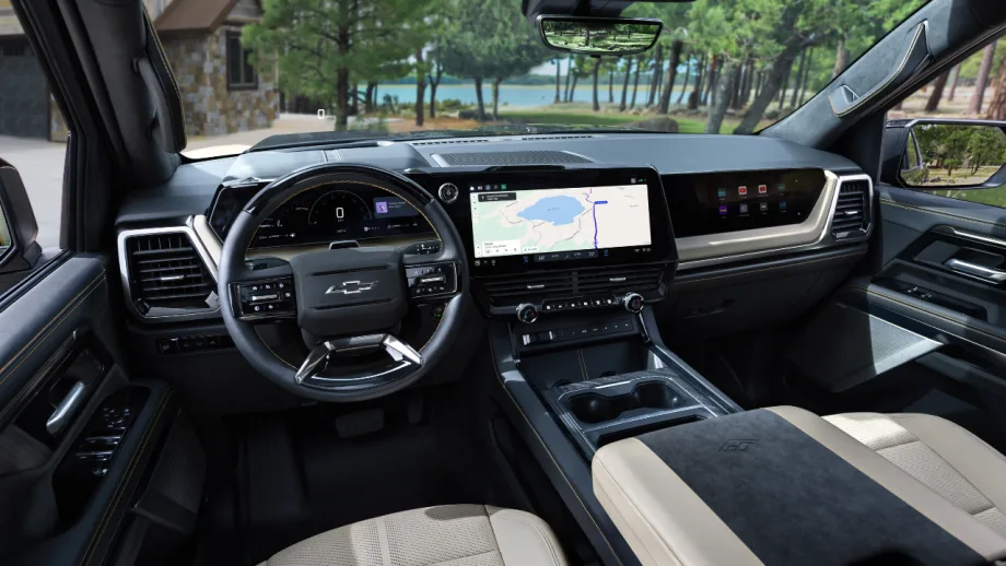 Interior of a 2027 Chevrolet Silverado showing the steering wheel, digital instrument cluster, large center touchscreen with navigation, and passenger-side display.