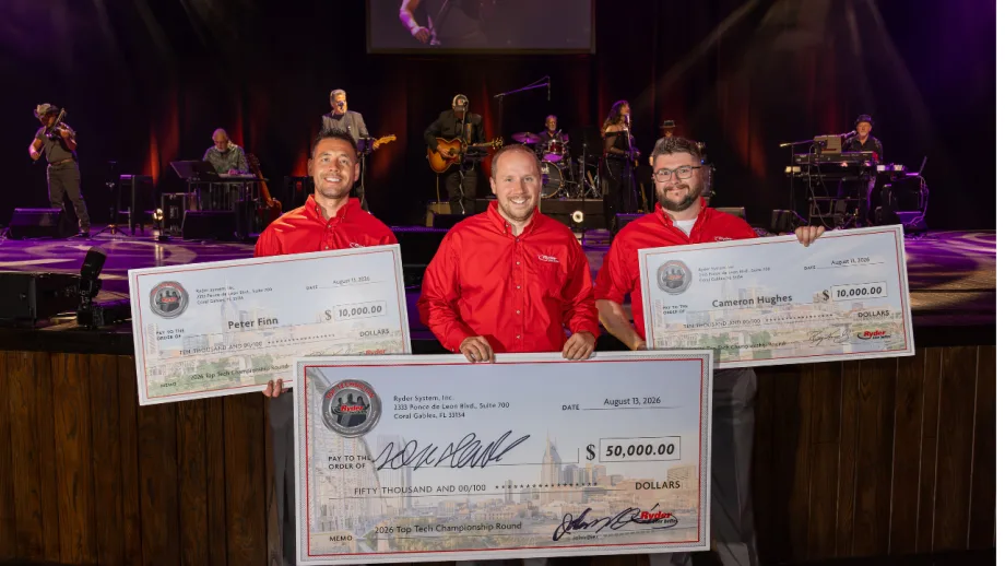 Three Ryder technicians in red shirts hold oversized prize checks after the 2026 Top Tech Championship, with a live band performing on stage behind them.