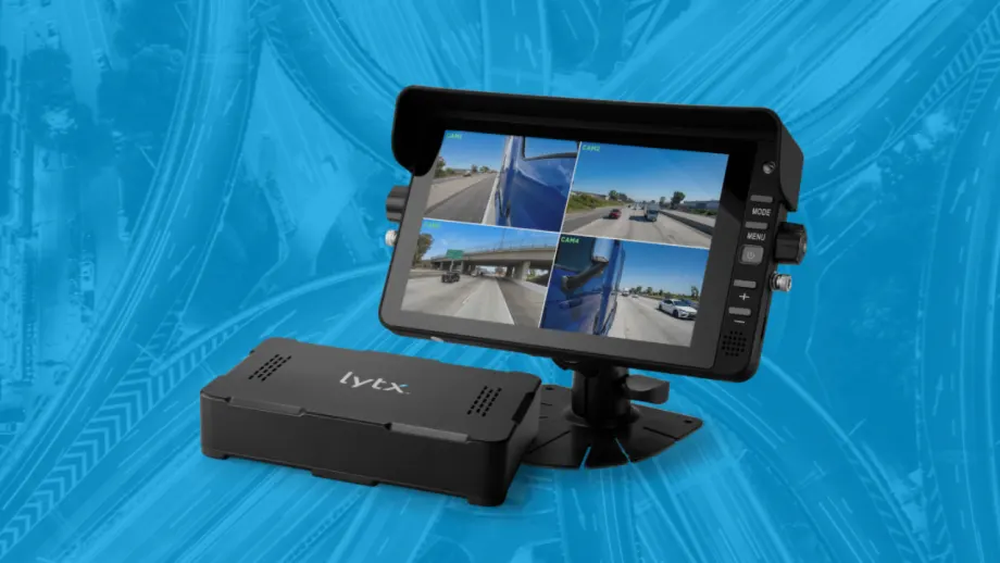 Lytx 360 Hub Kit featuring an in-cab monitor displaying four exterior camera views alongside the system’s hub, shown against a blue highway interchange background.