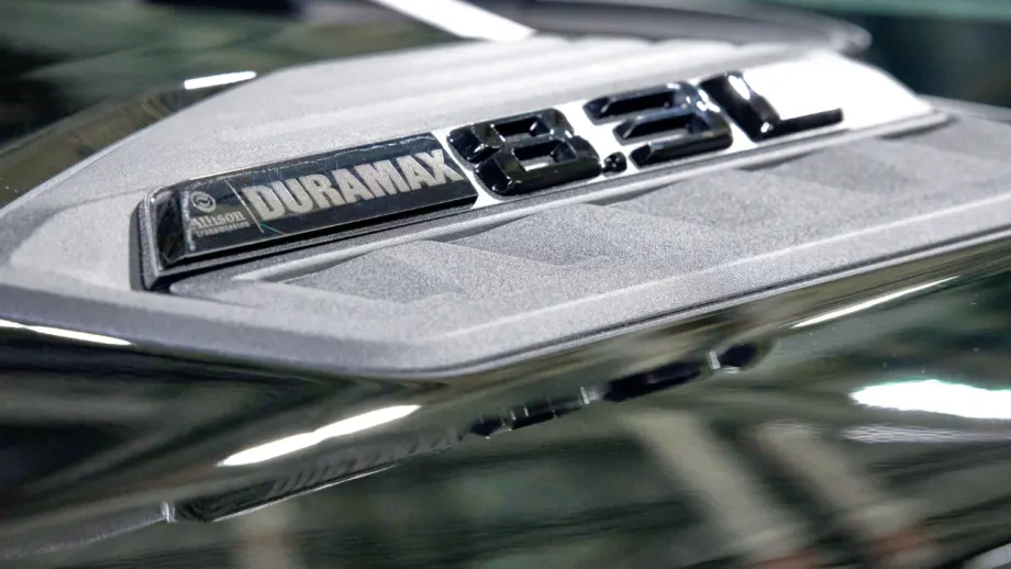 Close-up of a Duramax 8.3L Allison Transmission badge mounted on a vehicle hood, highlighting the engine designation and metallic trim.