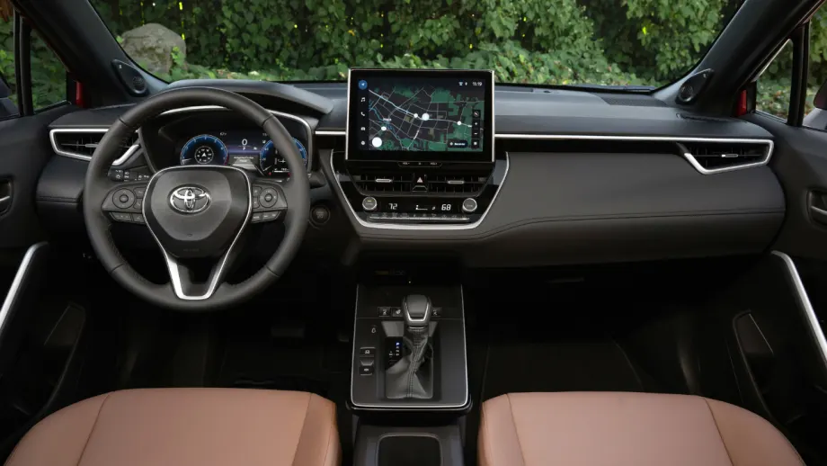 Interior of a 2027 Toyota Corolla Cross XLE showing the steering wheel, center touchscreen, digital driver display, and front seats.