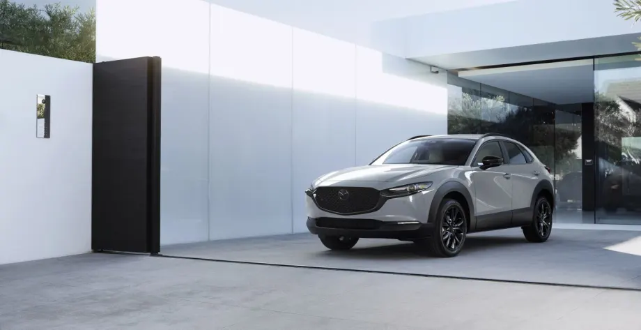2026 Mazda CX-30 compact SUV parked in front of a modern home, showcasing updated styling and design.