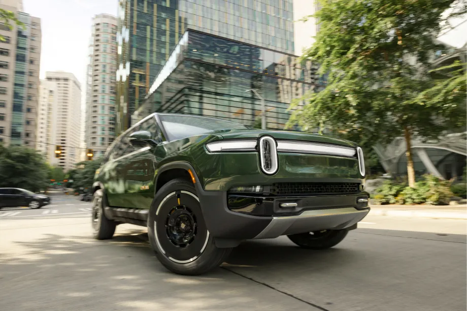 Rivian electric SUV driving through a city street, representing the company’s growing EV lineup and expansion plans.