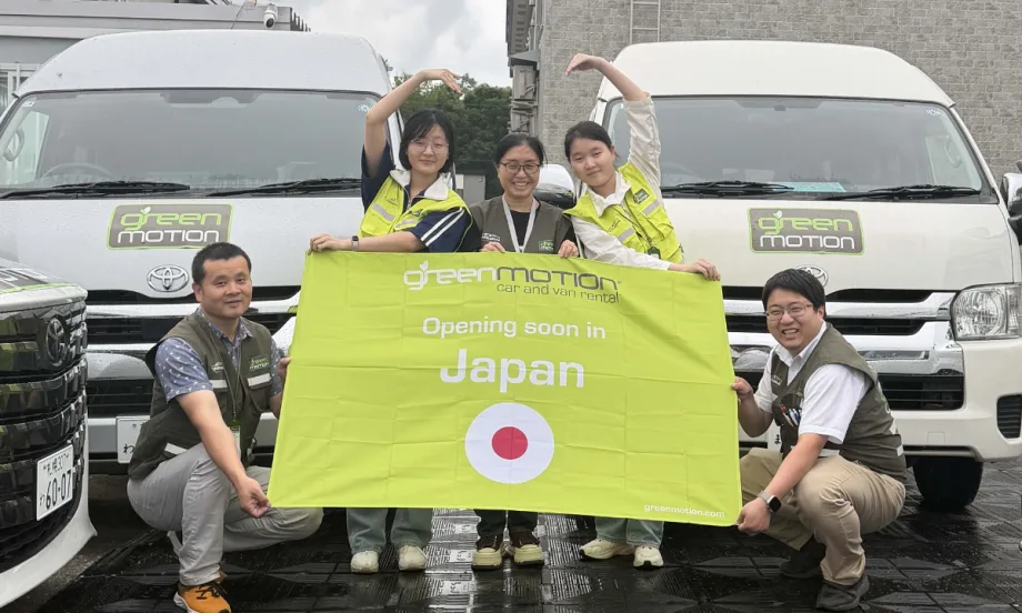 Green Motion team with banner bearing Japanese flag.