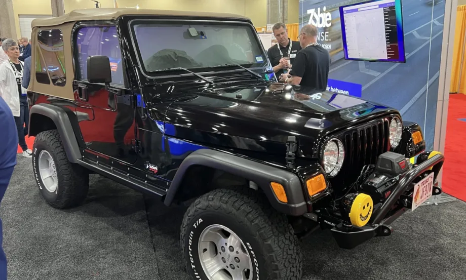 A black Jeep is displayed at the Zubie-Bosch-TSD exhibit during the International Car Rental Show.