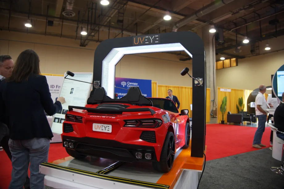 A red sports car sits underneath and AI-driven damage detection scanner.