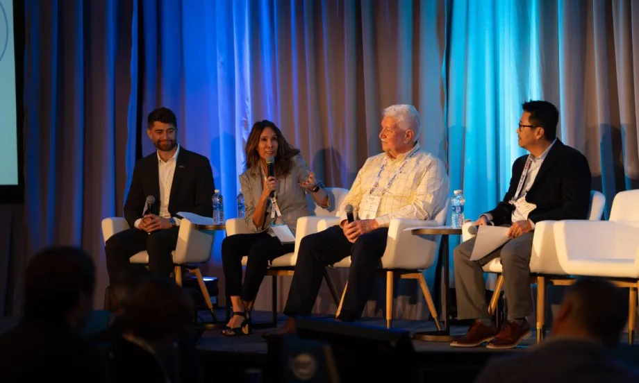 A panel of remarketing managers and experts on stage before a conference audience.