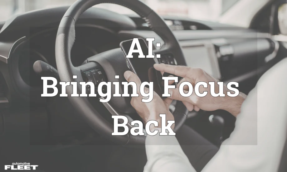A person in a car on their phone behind the steering wheel.